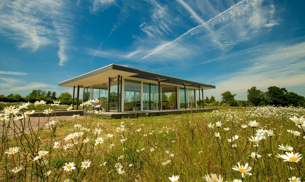 The glass pavilion venue at Clandon Wood Nature Reserve surrounded by wildflowers